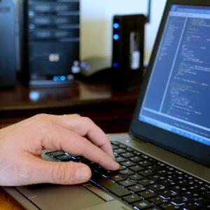 Male programmer working on computer code on his laptop. Data screen - data entry office IT Dept